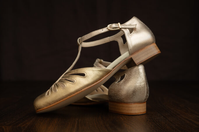 Riviera Flat Gold, a vintage sandal in a soft, warm gold tone with padded footbed and leather sole and heel